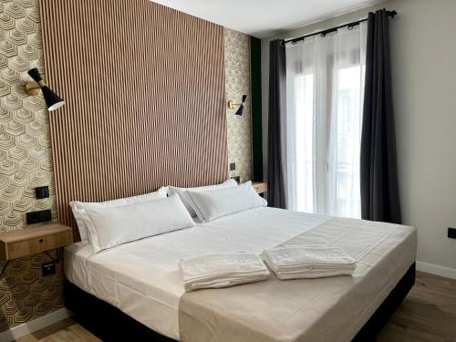 加的斯Aparthotel Luz de Gades - Suites Spa Gym - Adults Only的一间卧室配有一张带两个白色枕头的大床