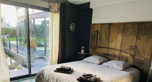 桑泰克Villa du Sieck 5 étoiles的一间卧室设有一张床和一个大窗户