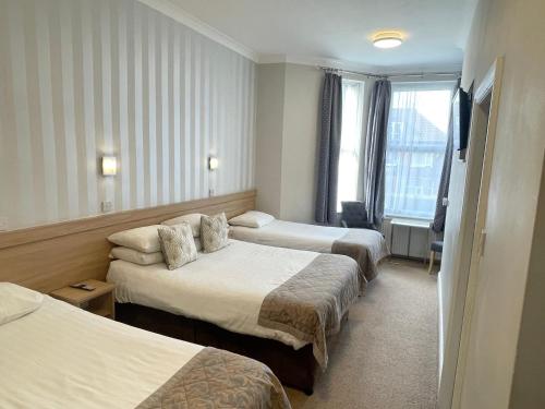 曼彻斯特The Westlynne Apartments的酒店客房设有两张床和窗户。