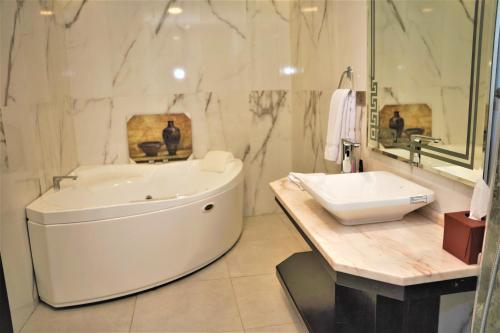 瓦迪穆萨Petra Canyon Hotel的白色的浴室设有浴缸和水槽。