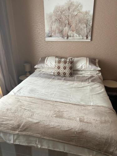 MartonVillage Rooms的卧室内的一张带白色床单和枕头的床