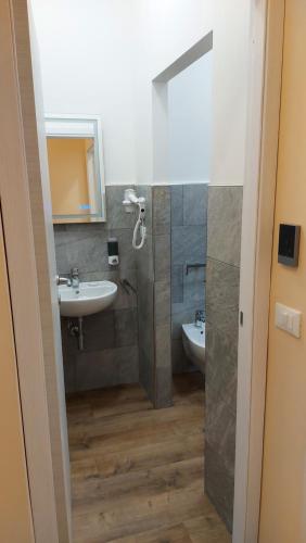 斯培西亚Glam Resort Luxury Lorenzo的一间带水槽、卫生间和镜子的浴室