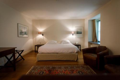 LembekeTer Heide (Kaprijke - Lembeke)的一间卧室配有一张床、一张桌子和一张沙发