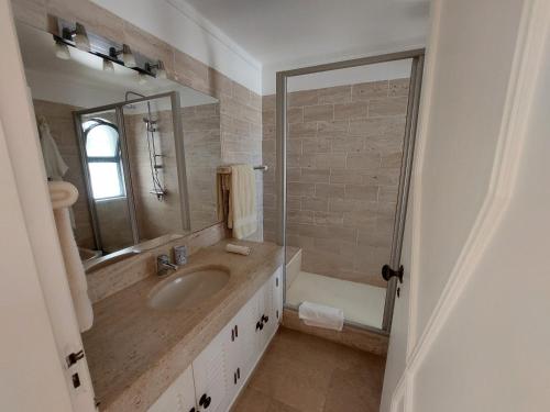阿尔曼萨Ancão Beach Apartment的浴室配有盥洗盆、镜子和浴缸
