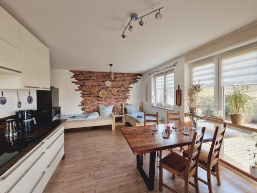 米滕瓦尔德Ferienwohnung Sunny的厨房以及带木桌和椅子的客厅。