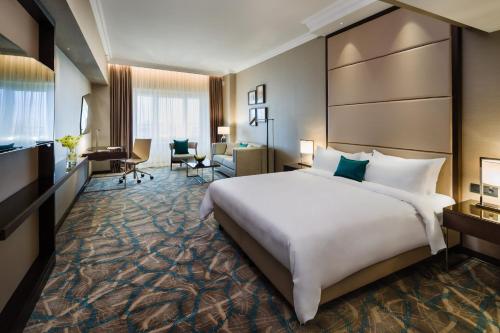 布加勒斯特布加勒斯特JW万豪大酒店的酒店客房设有一张大床和一张书桌。