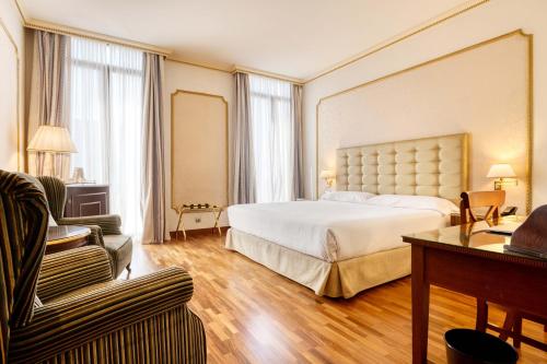 巴塞罗那罗杰德鲁里亚酒店的大型酒店客房,配有床和沙发