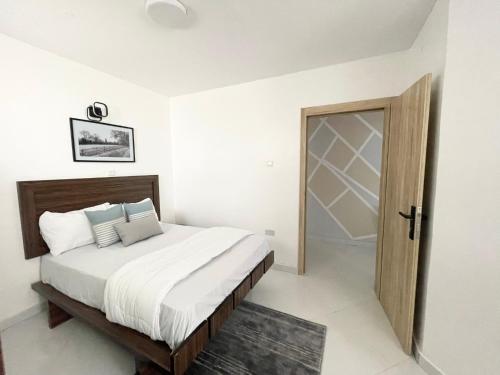 拉各斯Sigma Base Apartments的一间卧室配有一张床和一扇木门