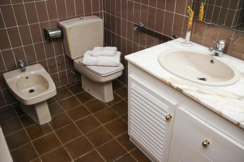 萨洛BAHIA II HomeStay by Turismar的一间带卫生间、水槽和小便室的浴室