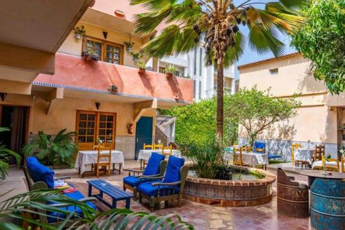 达喀尔卡萨玛拉达喀尔酒店的一座配有蓝色桌椅的庭院和一座建筑