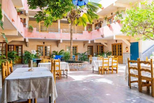 达喀尔卡萨玛拉达喀尔酒店的庭院内带桌椅的餐厅