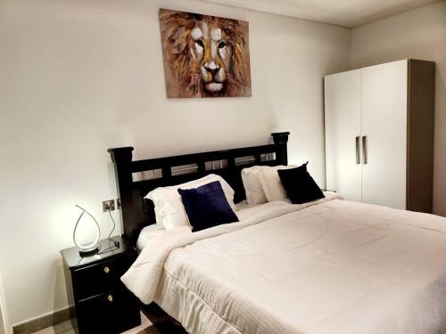 阿克拉Luxurious & Comfy Gem-5 Star Location-Pools Gym!的卧室配有一张大床,墙上挂有狮子画