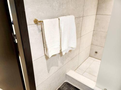 阿克拉Luxurious & Comfy Gem-5 Star Location-Pools Gym!的带淋浴和白色毛巾的浴室