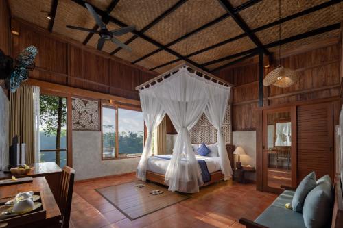 德格拉朗Sacred Valley by Pramana Villas的一间卧室配有一张带天蓬的床