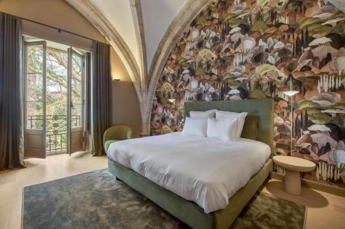里昂Les Suites de l'Ile Barbe的一间卧室设有一张带花卉墙壁的大床