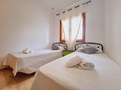 奇克拉纳－德拉弗龙特拉Apartamentos Turísticos La Carrajolilla的配有2张床的白色墙壁和窗户。