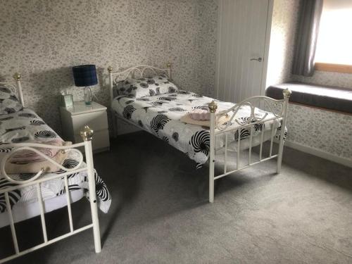 Upper BaybleTwo Chimneys的一间卧室设有两张单人床和一个窗户。