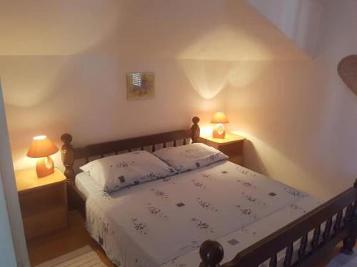 斯拉汀Apartment in Slatine with sea view, terrace, air conditioning, WiFi 5147-1的一间卧室配有一张带两张台灯的床铺。