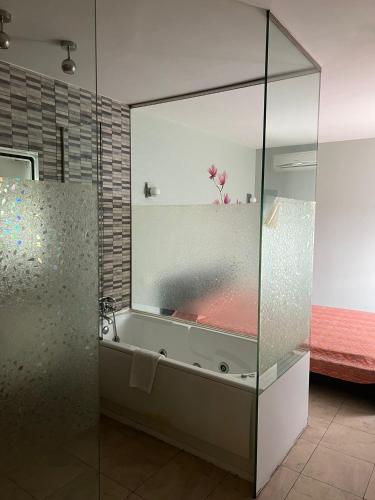 韦斯卡Hostal - Restaurante Asador Esperanza的浴室配有带浴缸的玻璃淋浴间