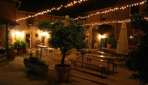 克分楞麦穆勒尔酿酒厂旅馆的庭院里设有桌子和树灯。