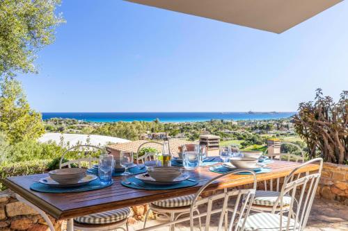维拉西米乌斯Villa Corallo - FREE WIFI - 1km from the beach的天井上配有带椅子和玻璃杯的木桌