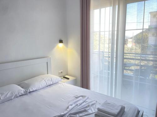 卡萨米尔Villa Denis Ksamil的卧室设有一张白色的床和大窗户