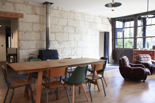 蒙特里夏尔Gite La Gazo - Grande maison chaleureuse.的一间带木桌和椅子的用餐室