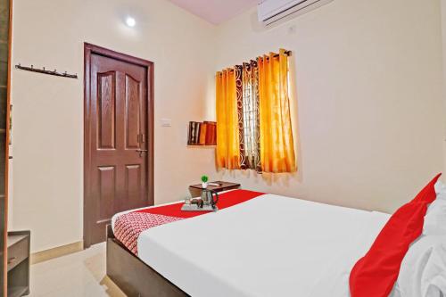 班加罗尔Super OYO Mn Residency Near Ragigudda Sri Prasanna Anjaneyaswamy Temple的卧室配有白色的床和窗户。