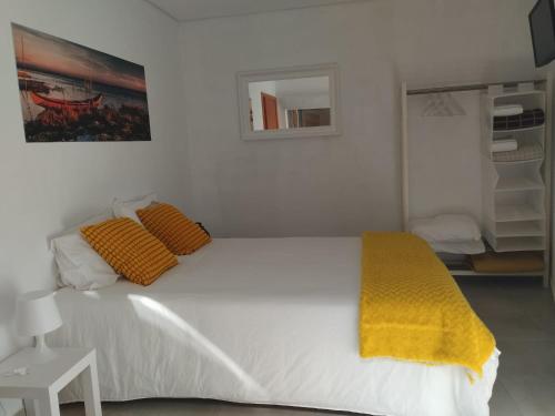 圣雅辛图The Ferry House的卧室配有白色床和黄色毯子