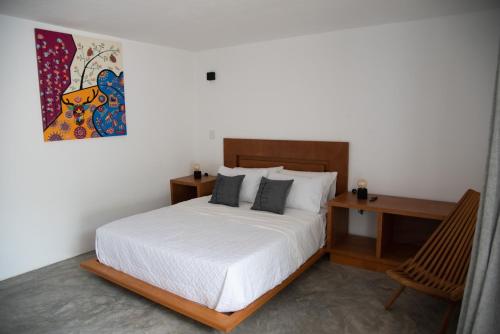 迪坡斯特兰Casa Naâmja的一间卧室配有一张床、一张书桌和一幅画