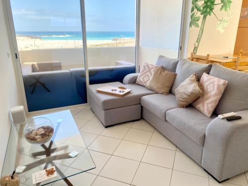 萨尔雷Terra Kriola的带沙发的客厅,享有海滩美景
