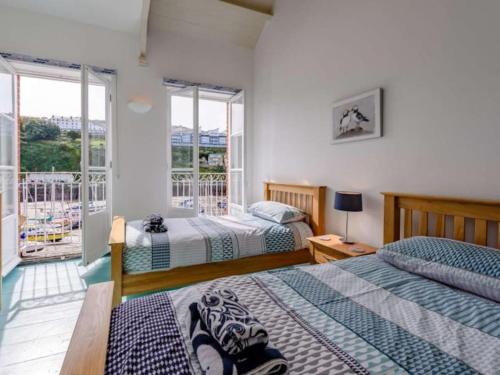 伊尔弗勒科姆Ultimate Harbourside的一间带两张床的卧室和一个阳台
