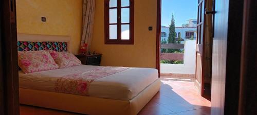 卡博尼格洛Complexe Mouna Cabo Negro的一间卧室设有一张床,享有阳台的景色