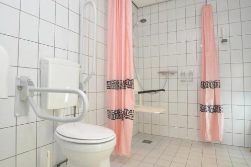 埃克斯鲁木伦乌克酒店的一间带粉红色淋浴帘和卫生间的浴室