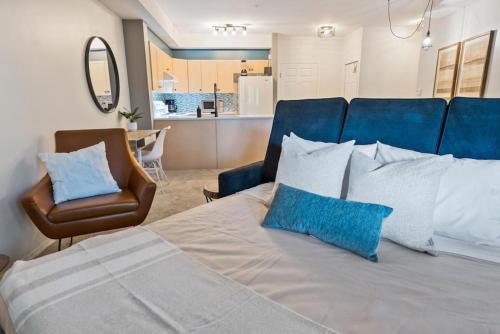 基洛纳Gorgeous Condo, Perfect Okanagan Getaway 1207的一间卧室配有一张带蓝色枕头的床和一把椅子
