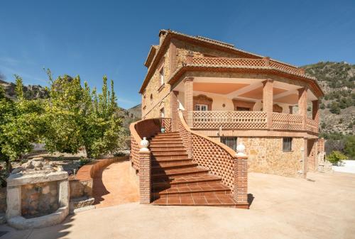 OlivaresCasa Rural Villa la Gaviota con Piscina y Barbacoa junto a Ruta del Gollizno en Olivares的砖房,前面有楼梯