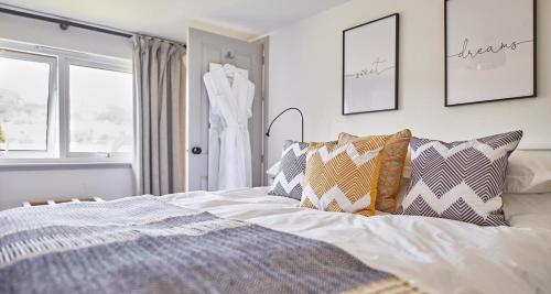 LogieraitEast End Cottage的一间卧室,配有一张床,一连串挂在窗户上的连衣裙