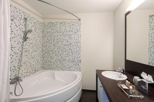 布鲁日Dukes' Apartments Grand Place的白色的浴室设有浴缸和水槽。