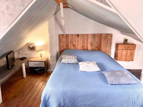 勒克罗图瓦gite le petit marin的阁楼卧室配有蓝色床