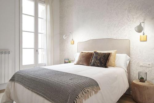 圣塞瓦斯蒂安NUEVO Apartamento en el centro de Donosti的卧室配有一张带白色床单和枕头的大床。