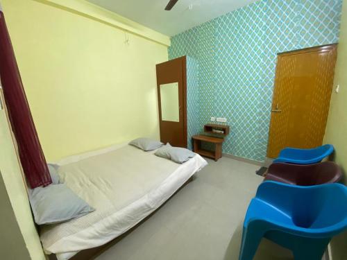VānūrFamily Guest House Pondicherry的一间卧室设有一张床和蓝色瓷砖墙