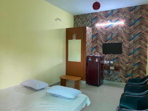 VānūrFamily Guest House Pondicherry的客房设有小冰箱和电视。