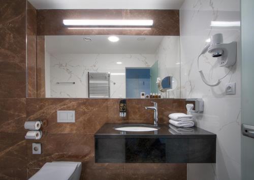 布拉格Hotel Essence的一间带水槽、卫生间和镜子的浴室