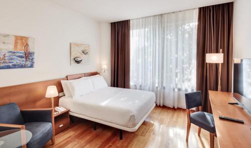 萨瓦德尔Sercotel Arrahona Sabadell的配有一张床和一张书桌的酒店客房