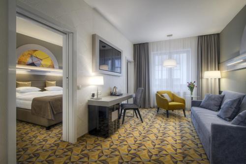 布拉格Hotel Essence的酒店客房配有一张床、一张书桌和一张沙发。