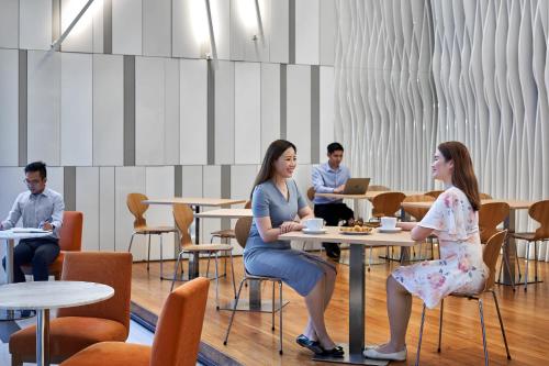 新加坡Holiday Inn Express Singapore Orchard Road, an IHG Hotel的一群坐在餐厅桌子上的人