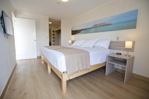 利马乌尔巴诺米拉帕尔多公寓的卧室配有一张白色的大床和一张桌子
