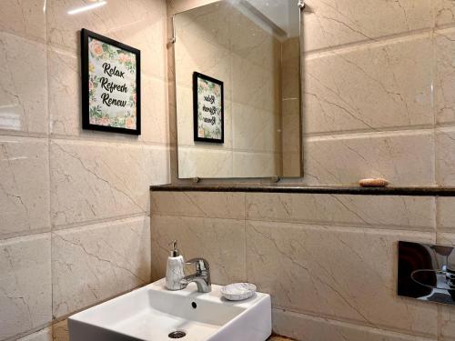 瓦加托Luxurious Nirvana Apartment 2BHK的一间带水槽和镜子的浴室