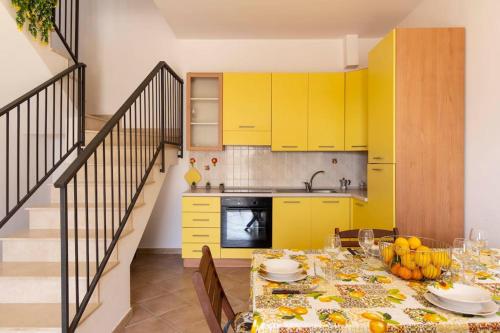 诺托玛丽娜Villa vista mare ~Villa Dafne~的厨房配有黄色橱柜和餐桌