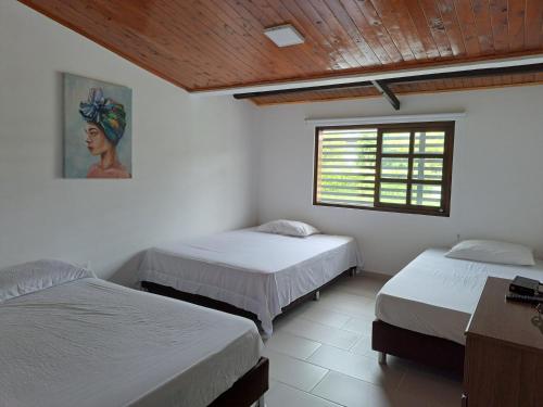 金巴亚Casa de Campo Las Partidas的一间卧室设有两张床,其中设有窗户。